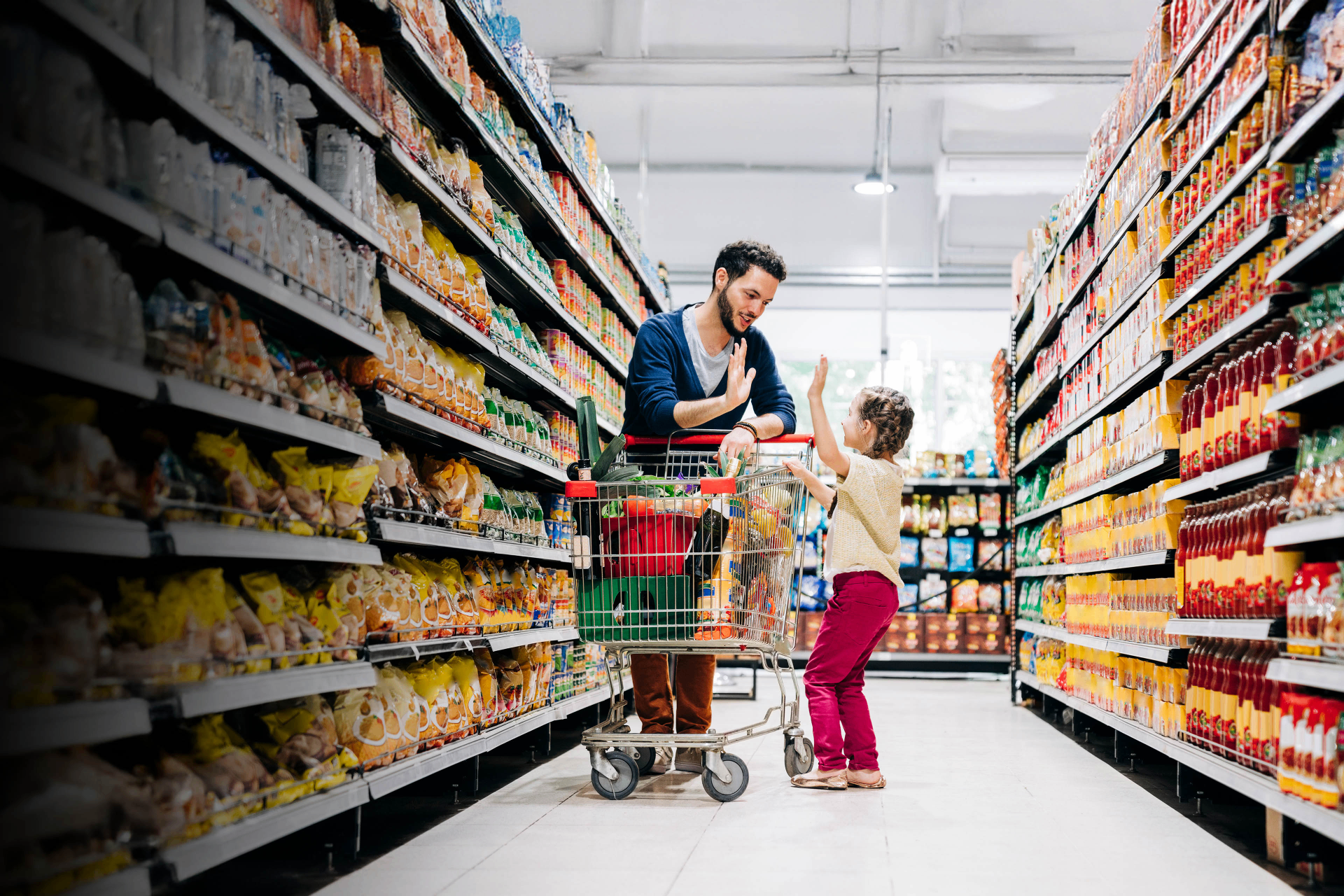 Father and daughter shopping in grocery store aisle