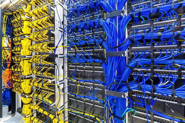 Professional structured cabling installation showing organized yellow and blue cables in a modern data center with proper cable management